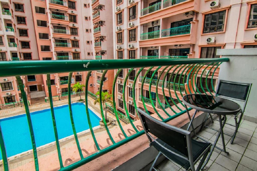 einen Balkon mit einem Tisch, Stühlen und einem Pool in der Unterkunft Marina Condominium Holiday Homestay in Kota Kinabalu