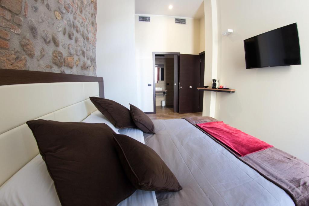 una camera con un letto e una televisione a muro di Arena Luxury Rooms a Verona