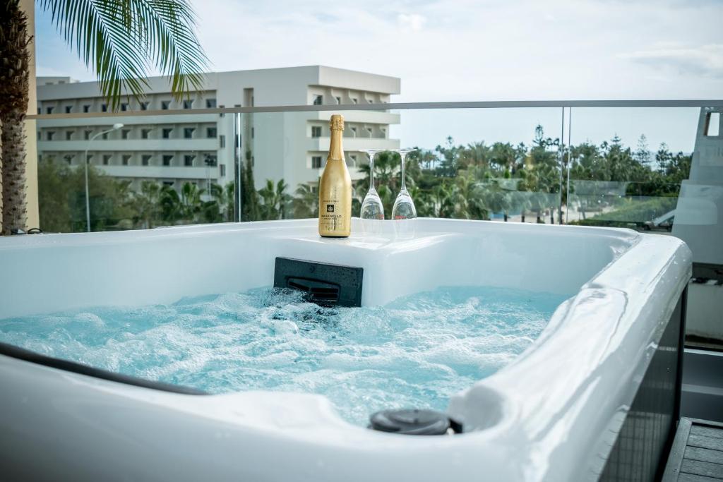 eine Badewanne mit einer Flasche Champagner in der Unterkunft Paradi Nissi Golden Sands Apartment in Ayia Napa