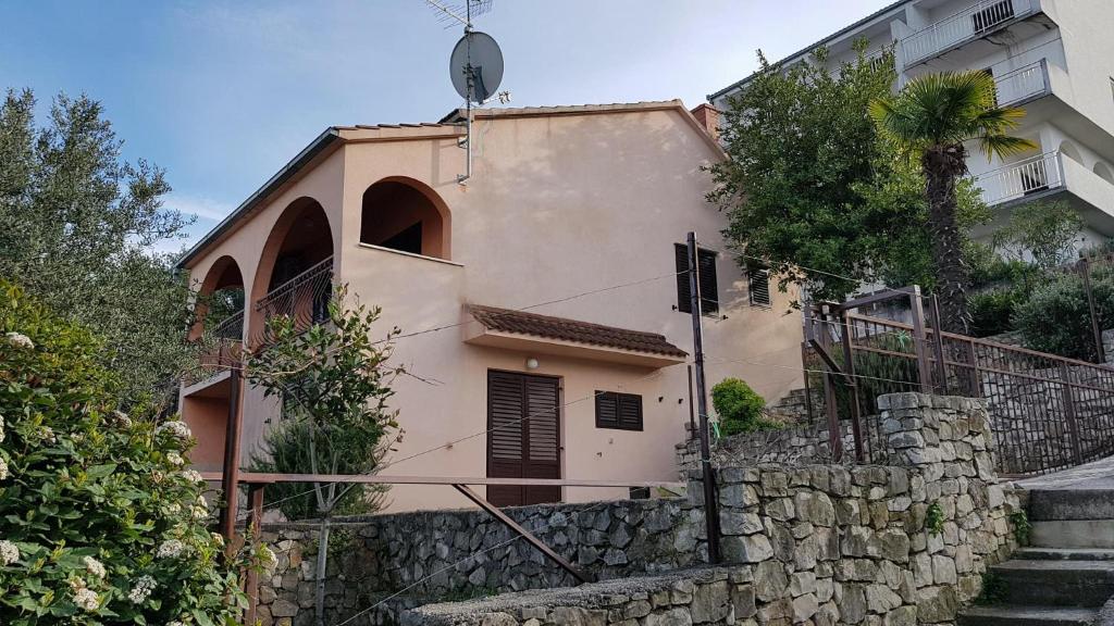 una casa con un muro di pietra accanto a un edificio di Apartmants Amor a Okrug Donji