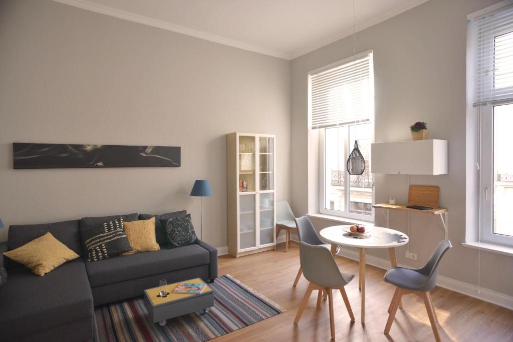 uma sala de estar com um sofá e uma mesa em City-Apartment Reger Privatparkplatz em Krefeld