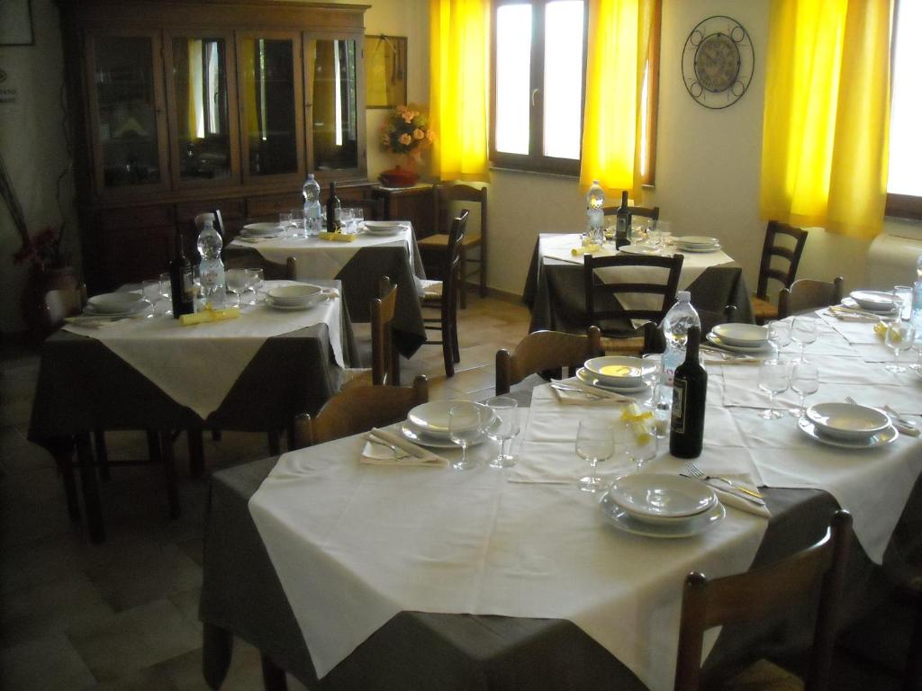 a dining room with tables and chairs with white tablecloths at Agriturismo Depalmas in Stintino