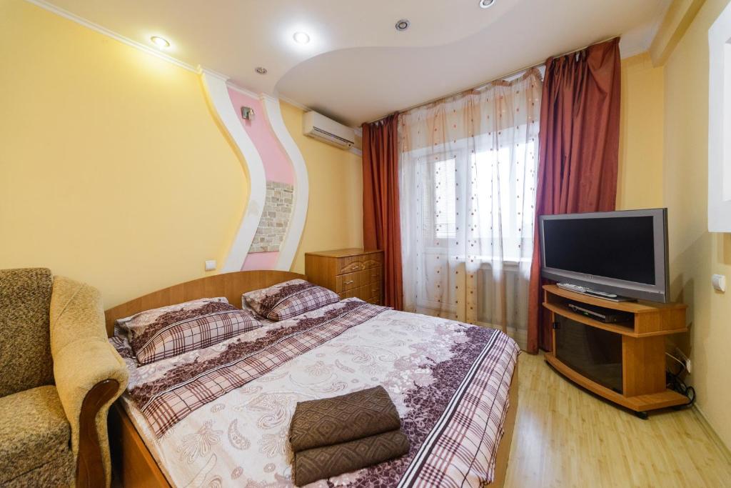 1 dormitorio con 1 cama y TV de pantalla plana en Obolonskiy Prospekt Apartments 7Б (194), en Kiev