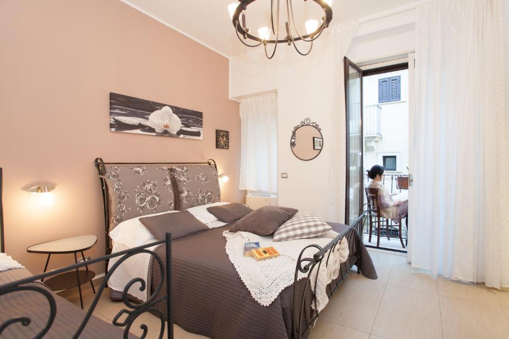 1 dormitorio con cama y lámpara de araña en B&B Trio D'Archi - La Pilozza Infiorata, en Caltagirone