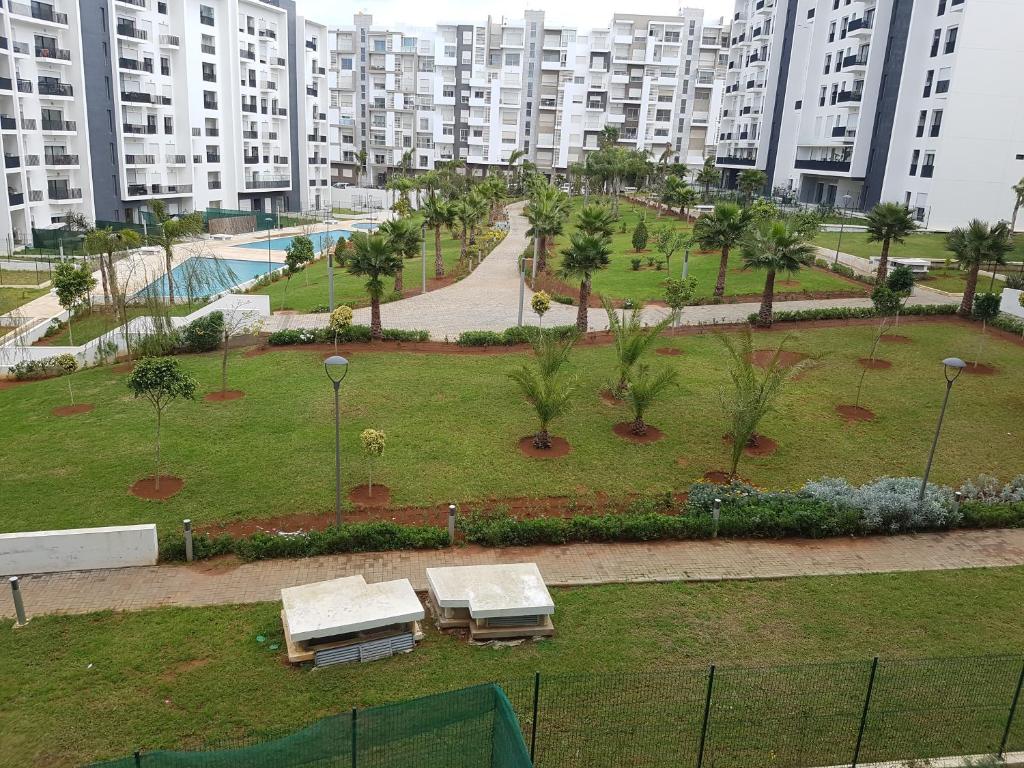 een park in een stad met banken en gebouwen bij Appartement avec Piscine à Hay Riad in Rabat