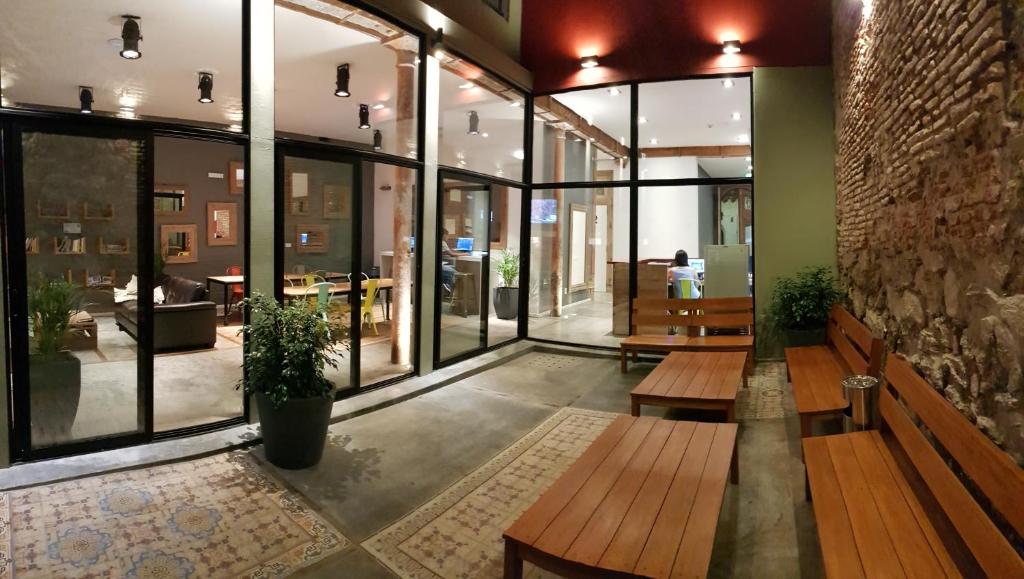 a lobby with benches and tables in a building at Circus Hostel&Hotel Montevideo in Montevideo