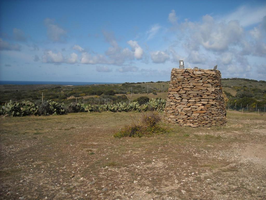 a stone wall sitting on top of a field at Agriturismo Depalmas in Stintino