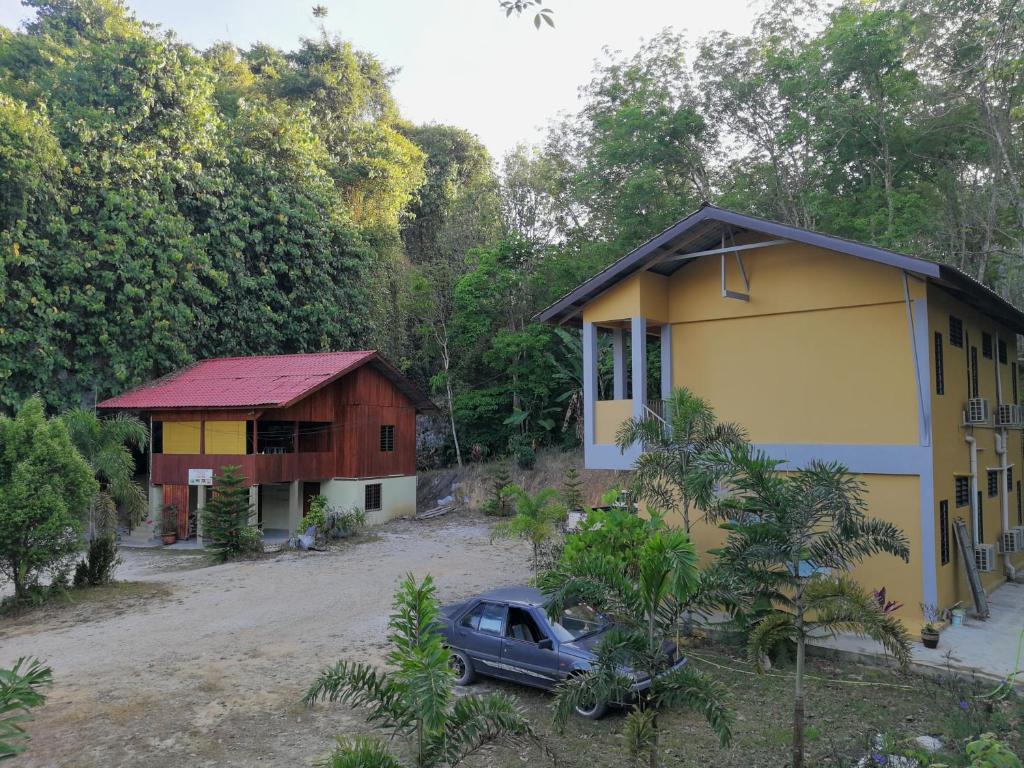 a house and a car parked in front of it at Country house Pulai Holiday Village in Gua Musang