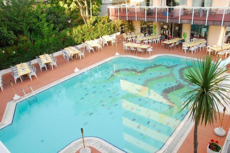 an overhead view of a large swimming pool with tables and chairs at Hotel Madison - Cattolica in Cattolica