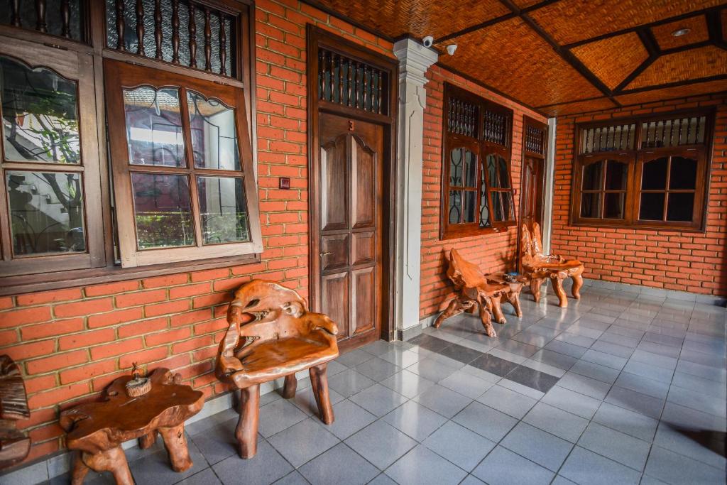 um alpendre com bancos na lateral de um edifício em Puri Agung Homestay em Kuta