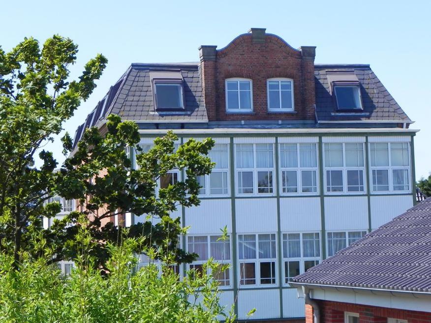 a large white building with a brick at Haus Therese Ferienwohnung *Feodora* (App.11) in Wittdün