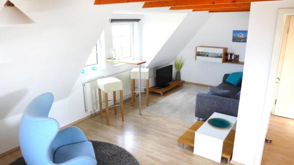 uma sala de estar com um sofá azul e uma televisão em Haus Nordlicht Ferienwohnung *Auer Lun* em Nebel
