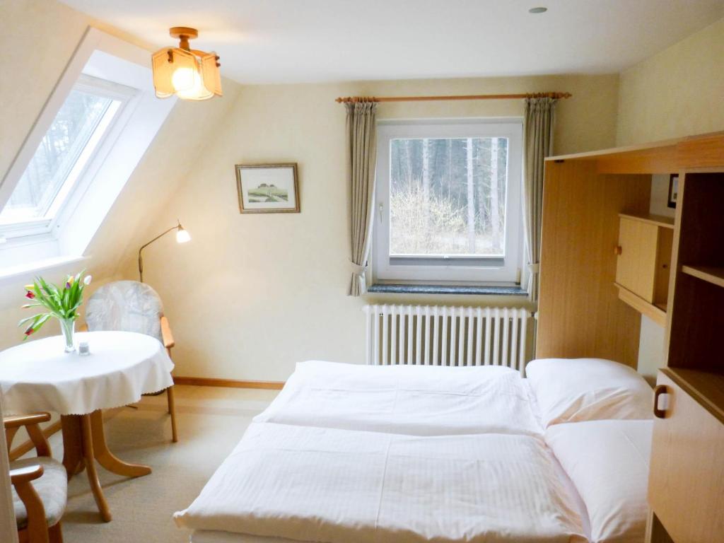 una camera con letto, tavolo e finestra di Haus *Üüs Aran* Wohnung Nr. 2 a Wittdün
