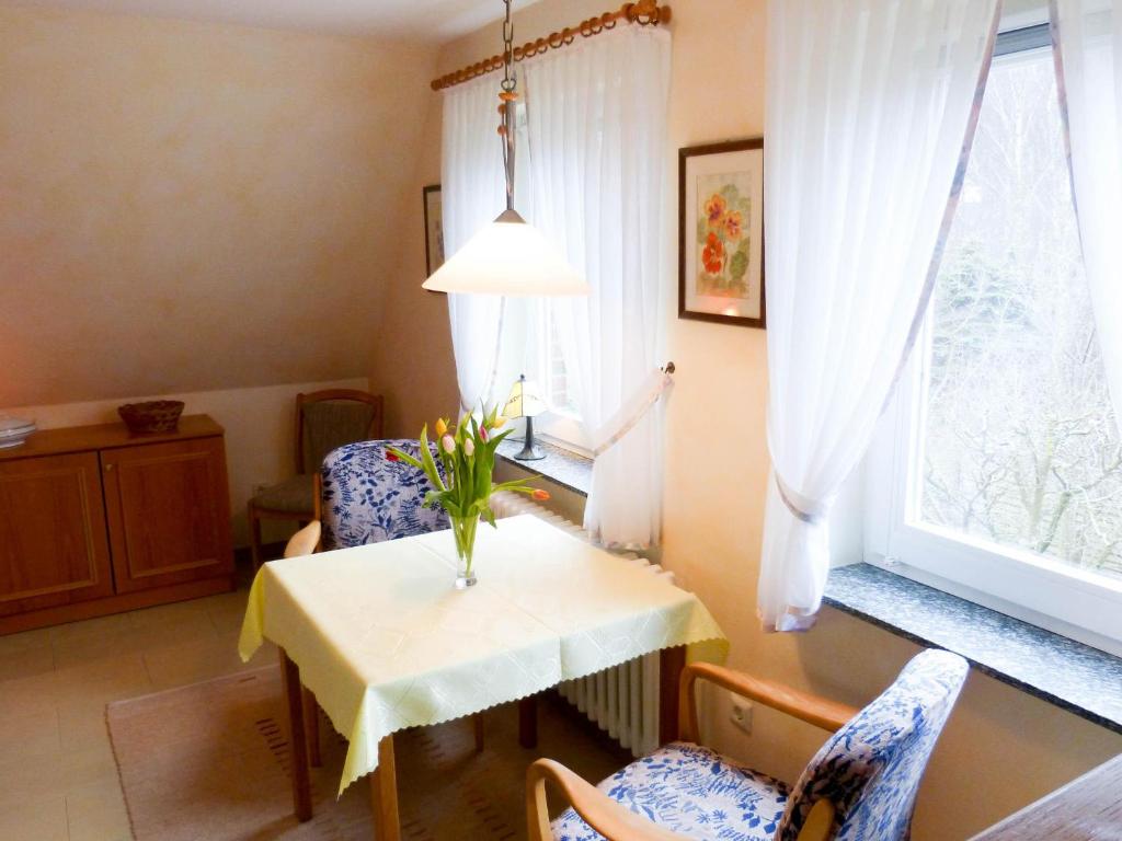 Zimmer mit einem Tisch, Stühlen und einem Fenster in der Unterkunft Haus *Üüs Aran* Wohnung Nr. 7 in Nebel