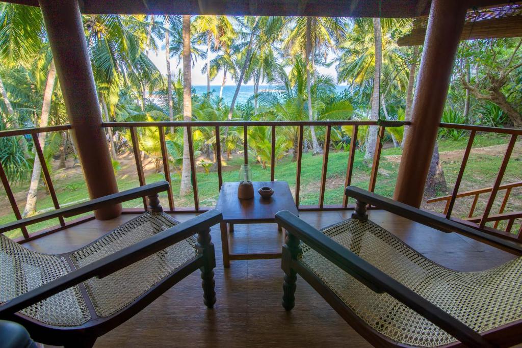 a patio area with chairs, tables and umbrellas at Palm Paradise Cabanas & Villas Beach Resort in Tangalle