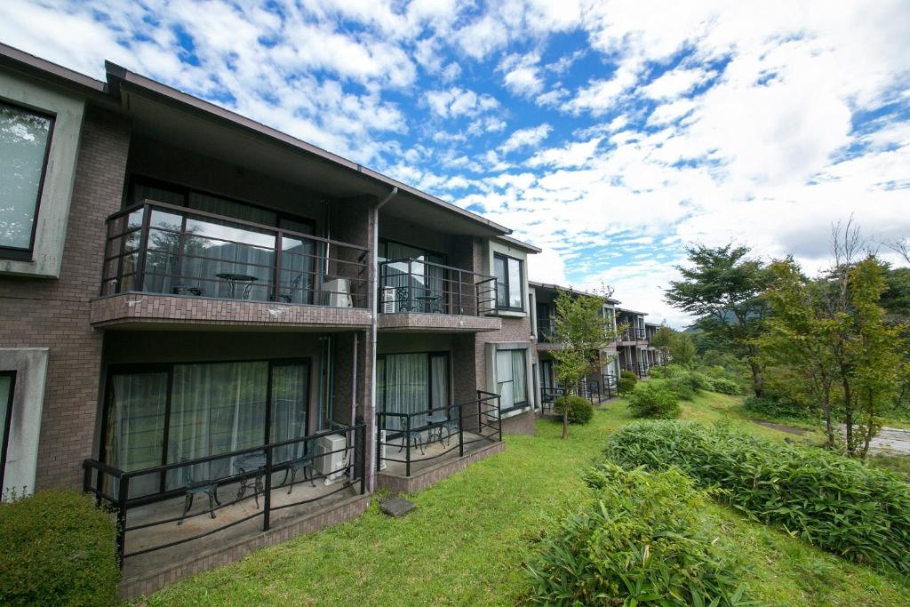 ein Apartmenthaus mit Balkon und Hof in der Unterkunft Stardust Village Hossyo in Kokonoe