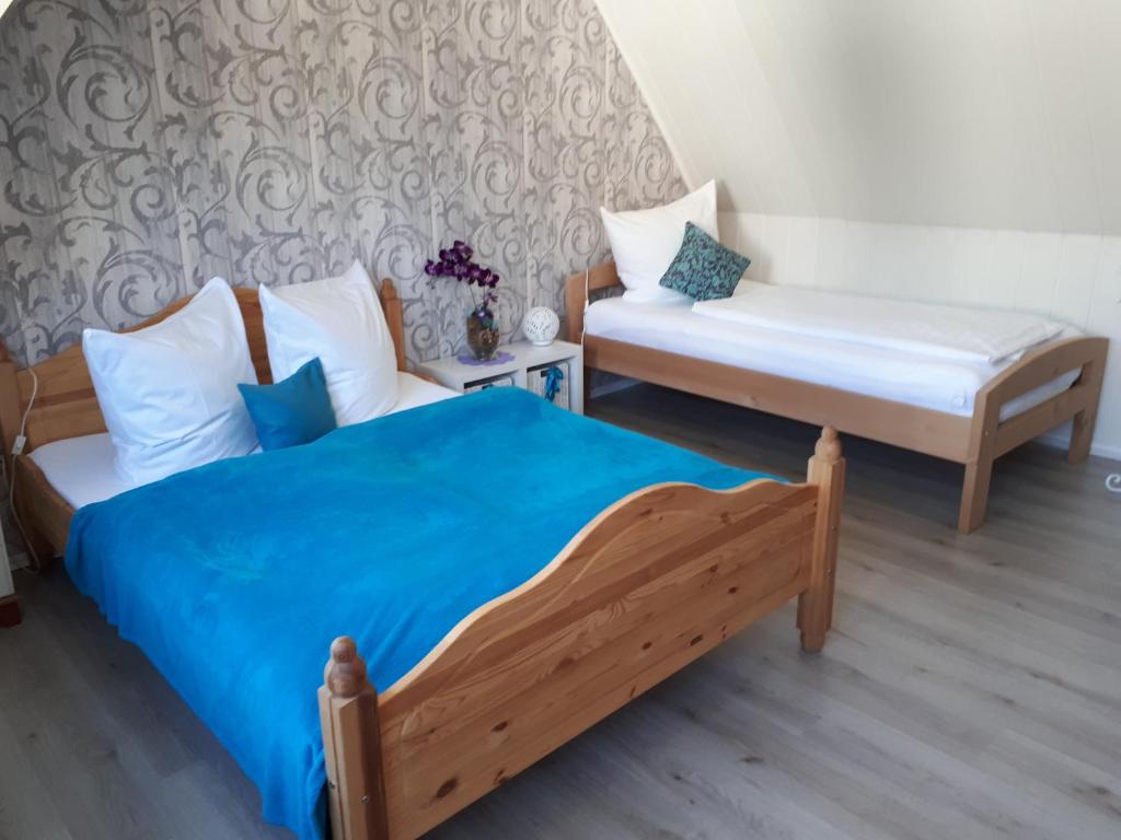 a bedroom with two beds and a bench in it at Haus Freitag in Itzehoe