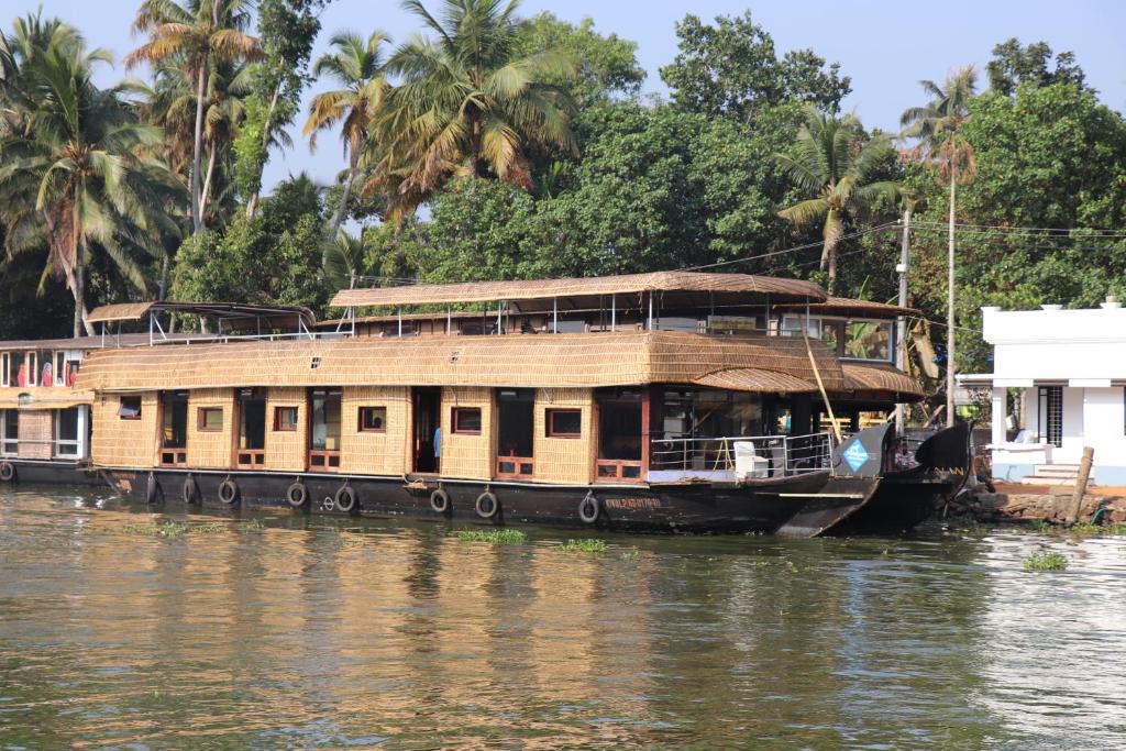 un barco de la casa está atracado en el río en Friends Cruise, Nightstay Houseboat-VACCINATED STAFF, en Alleppey