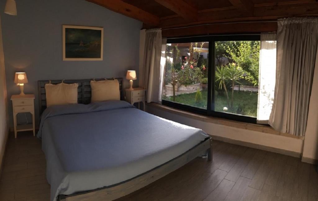 ein Schlafzimmer mit einem Bett und einem großen Fenster in der Unterkunft Villa Giulia in Parghelia