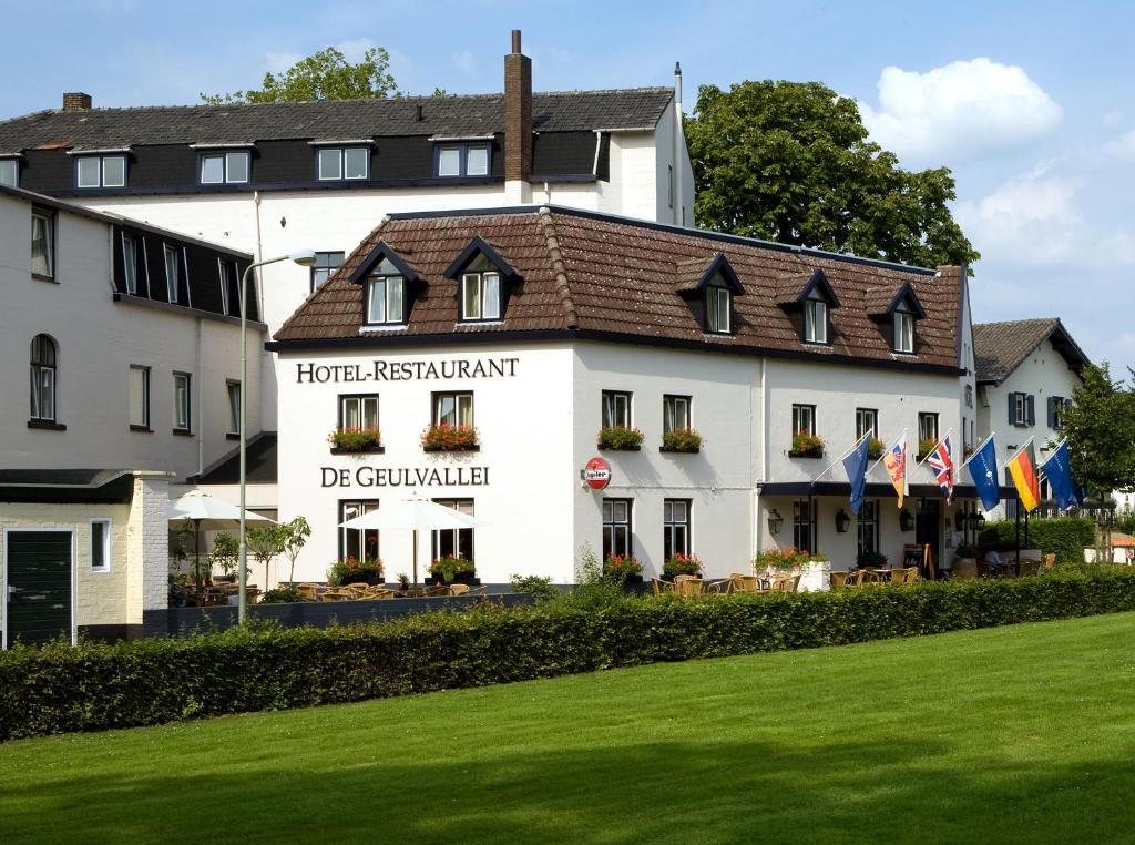 ein Hotel mit einer Liegewiese vor einem Gebäude in der Unterkunft Fletcher Hotel Restaurant De Geulvallei in Valkenburg