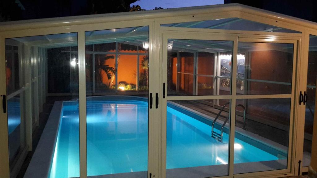 a swimming pool inside a house with glass doors at Villa Salvatore in San Leone