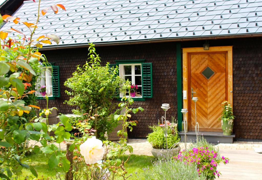 a brick house with a wooden door and flowers at Burgi Kefer in Bad Ischl