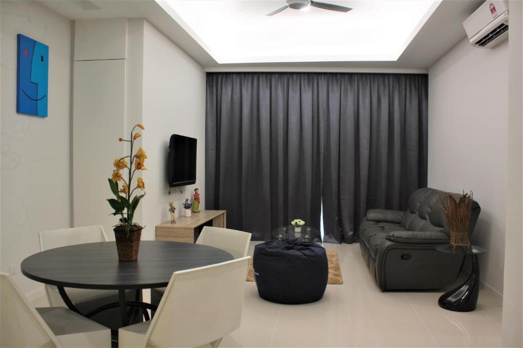 a living room with a table and a chair and a couch at Azure Residence Paradigm Mall in Petaling Jaya