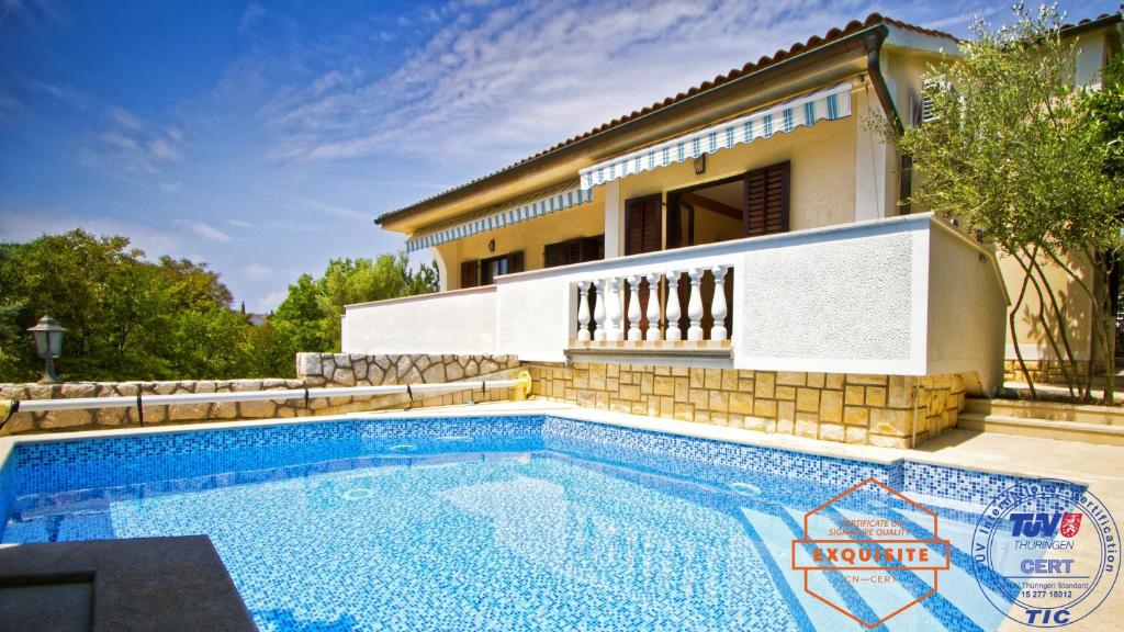 a swimming pool in front of a house at Villa Kovach in Krk