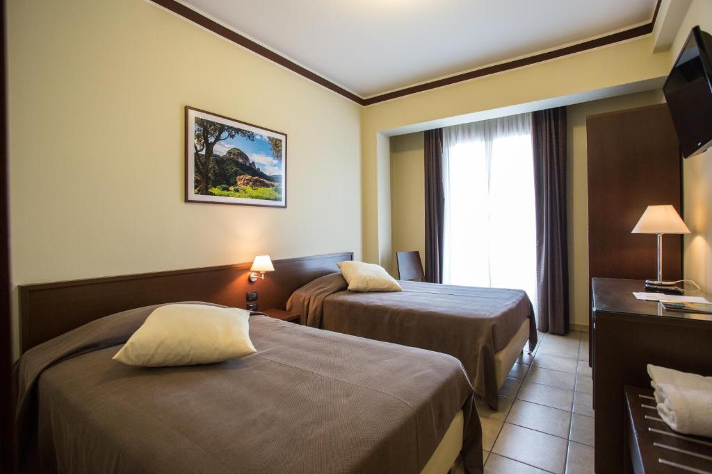 a hotel room with two beds and a television at Hotel Vittoria in Rosarno