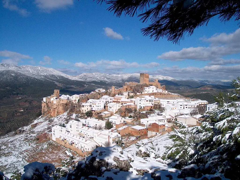 una ciudad en la cima de una montaña cubierta de nieve en Apartamentos Raisa, en Hornos