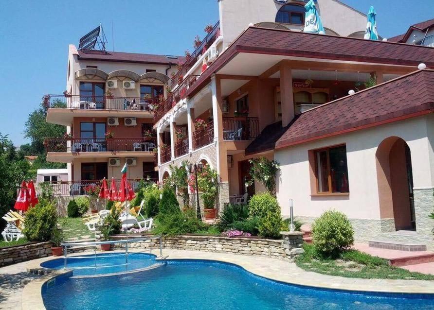 a hotel with a swimming pool in front of a building at Byala Perla Family Hotel in Byala