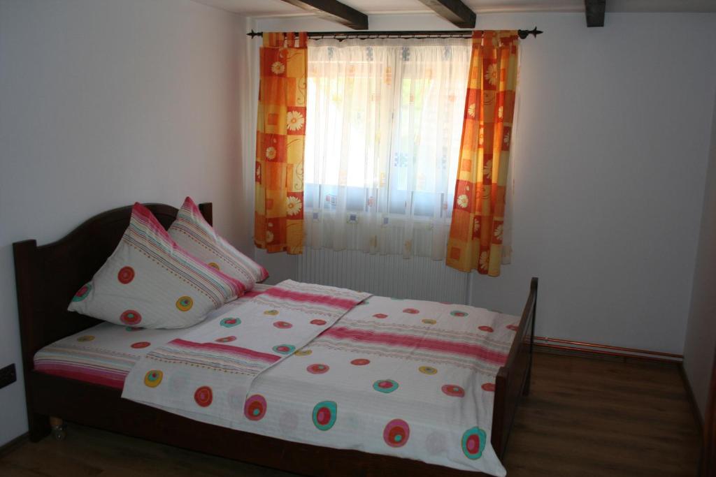a bedroom with a bed with pillows and a window at Dobarlica in Dobîrlău