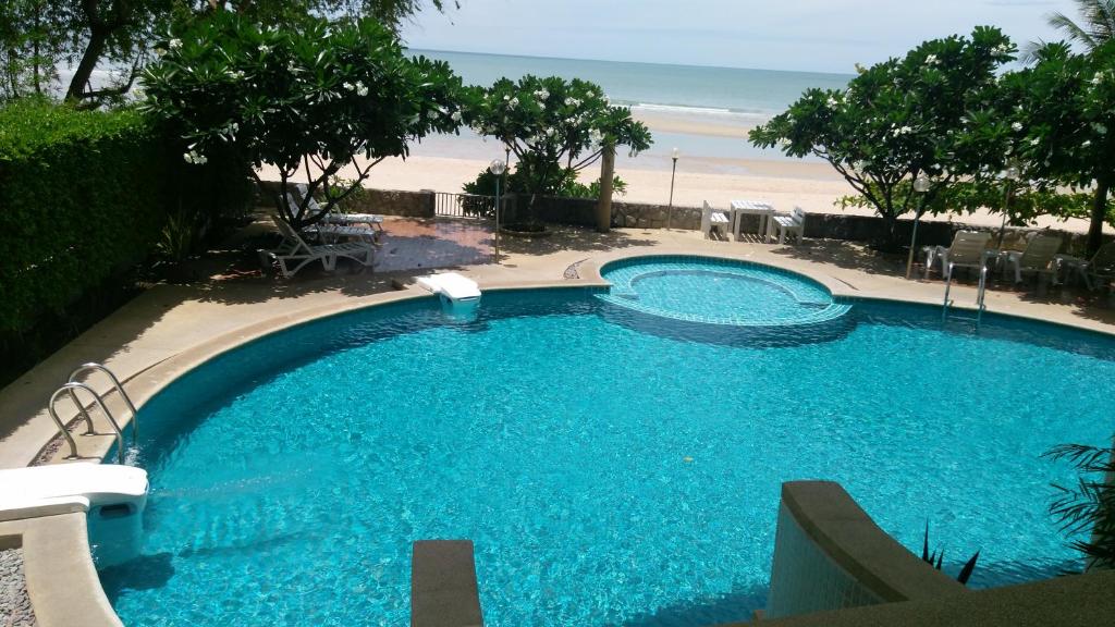 a swimming pool with a view of the beach at Beach Condo in Cha Am