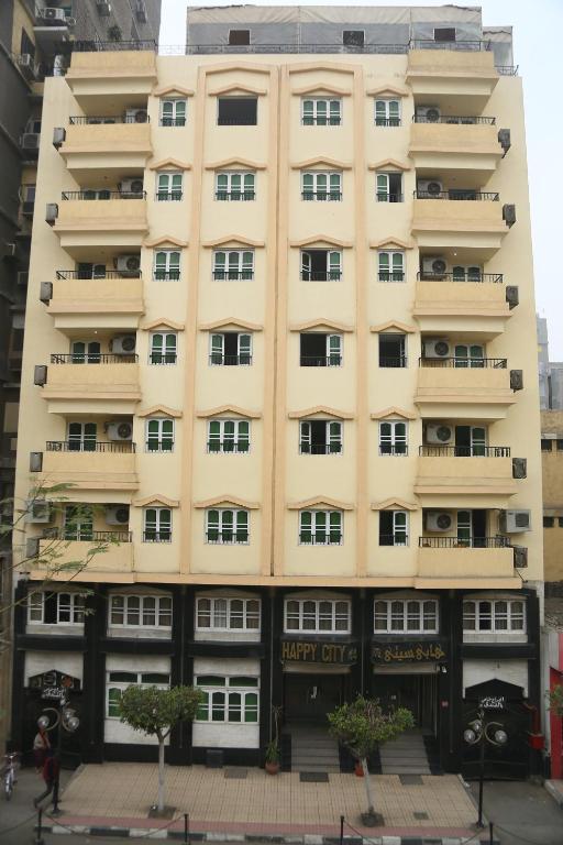 فندق هابي سيتي القاهرة في القاهرة: مبنى أصفر طويل مع نوافذ في المدينة