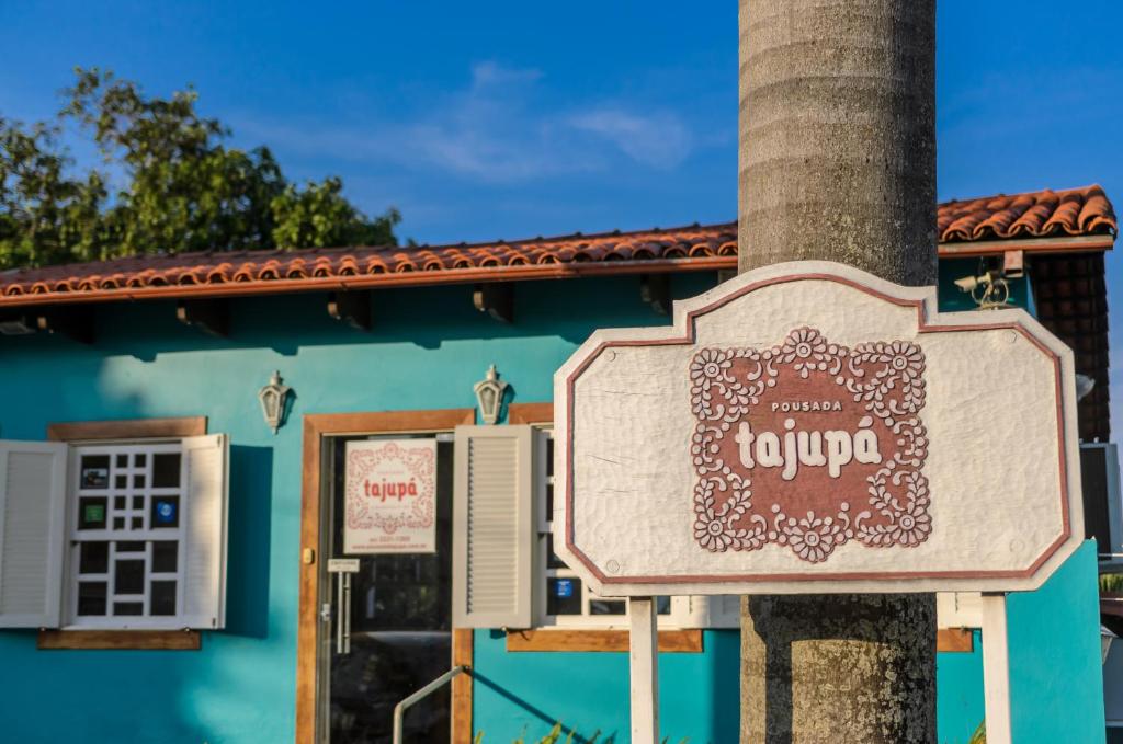una señal en un poste frente a un edificio en Pousada Tajupá, en Pirenópolis