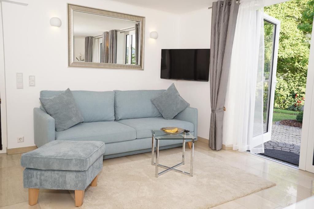 sala de estar con sofá azul y mesa en York Cottage Garden en Traben-Trarbach