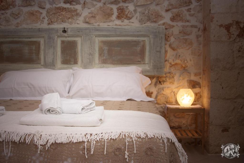 コンヴェルサーノにあるGli Amanti del Sognoのベッドルーム1室(タオル、ランプ付)