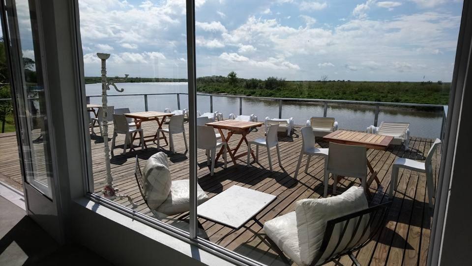 a deck with tables and chairs and a view of the water at Cabañas Aguaflorida in Gualeguay