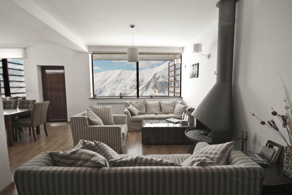 - un salon avec deux canapés et une grande fenêtre dans l'établissement Chalet Marina Gudauri, à Goudaouri