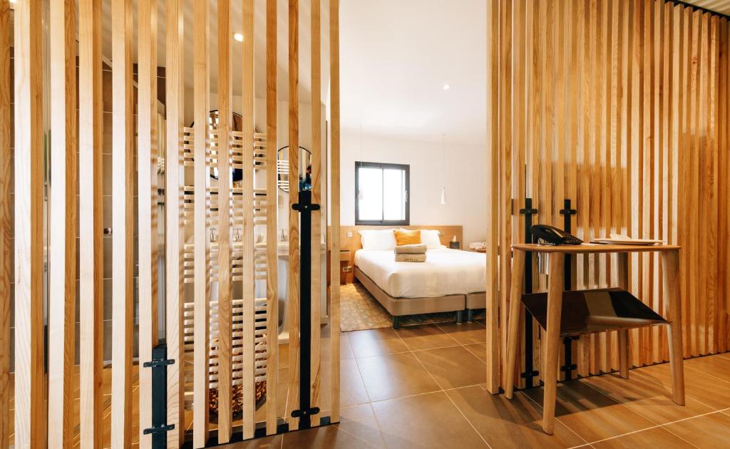 a room with a bed and a bedroom with wooden walls at Citta di Lume Suites &amp; Lofts in Porto-Vecchio