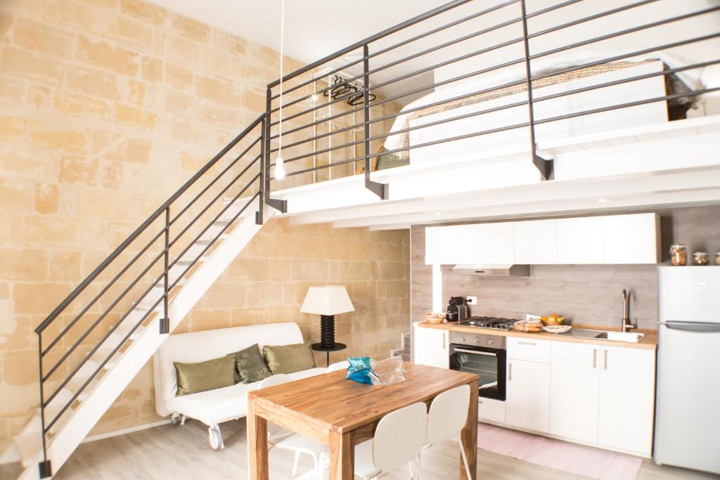 een keuken met een tafel en een trap bij Sulla roccia dei Sassi in Matera