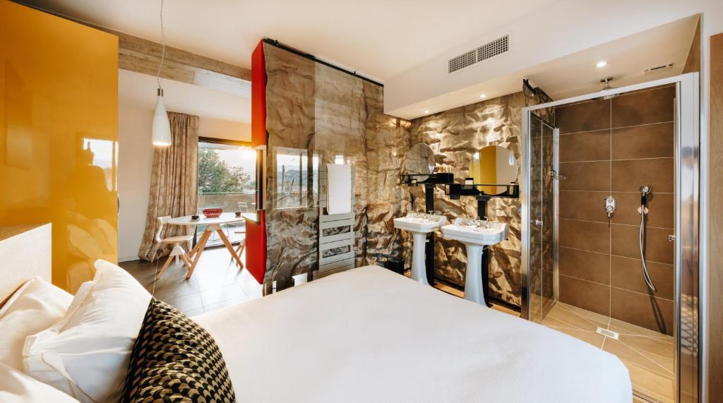 a bedroom with a bed and a bathroom with a shower at Citta di Lume Suites &amp; Lofts in Porto-Vecchio