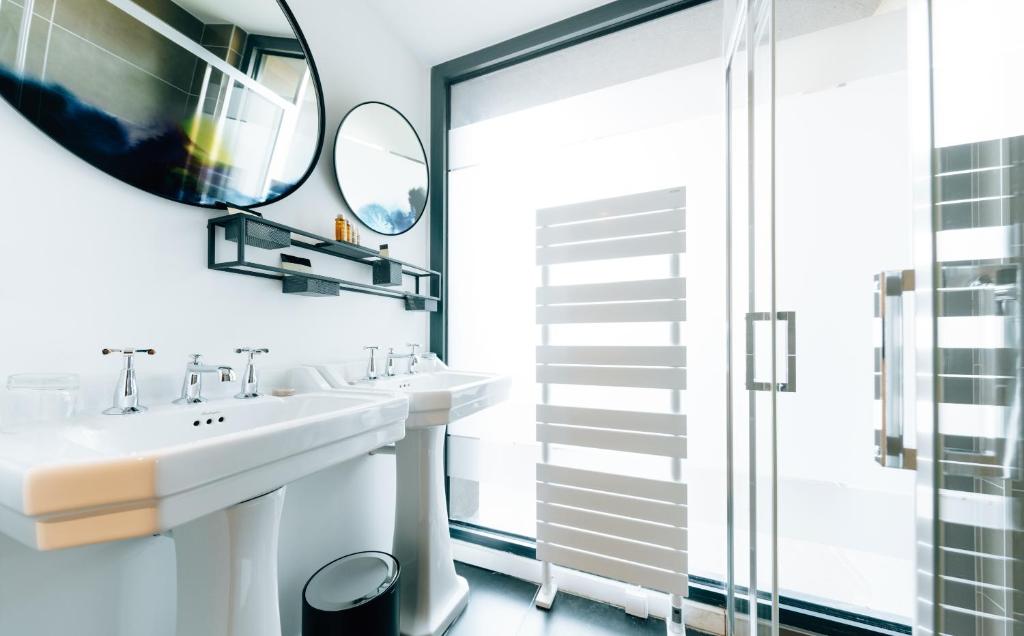 a bathroom with two sinks and a mirror at Citta di Lume Suites &amp; Lofts in Porto-Vecchio
