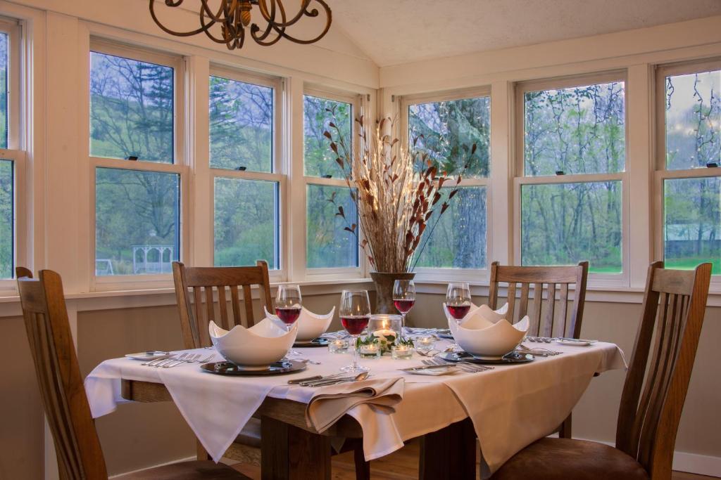 uma sala de jantar com uma mesa e janelas em The Lincoln Inn & Restaurant At The Covered Bridge em Woodstock