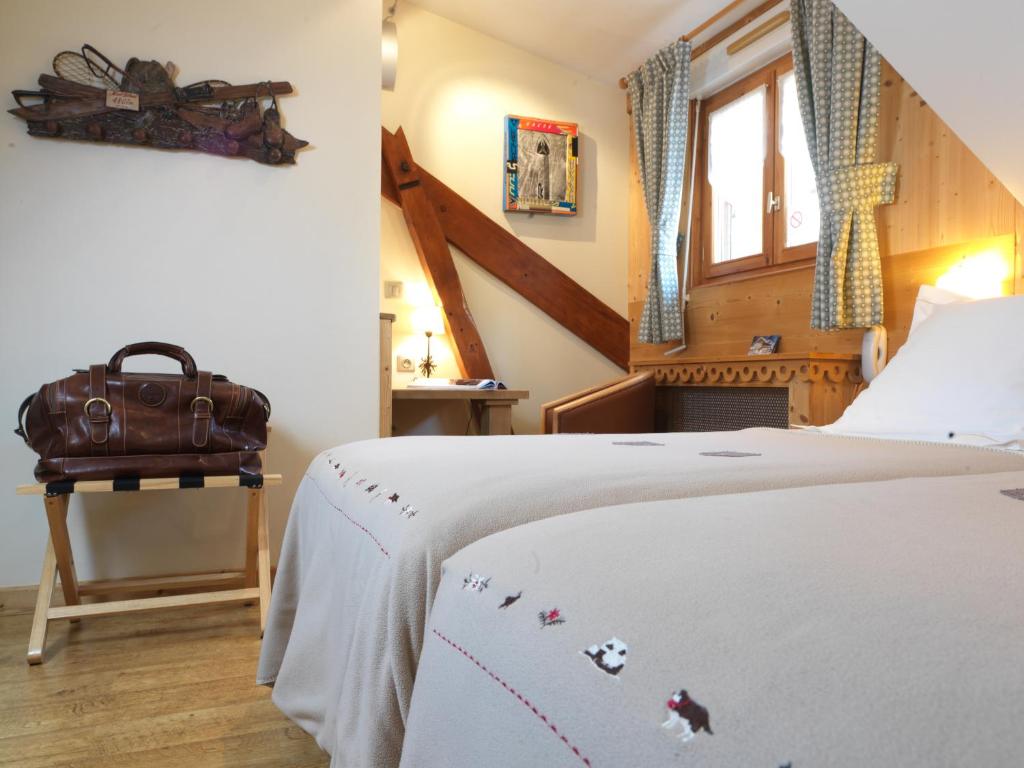 a bedroom with a bed and a bag on a table at Auberge du Manoir in Chamonix