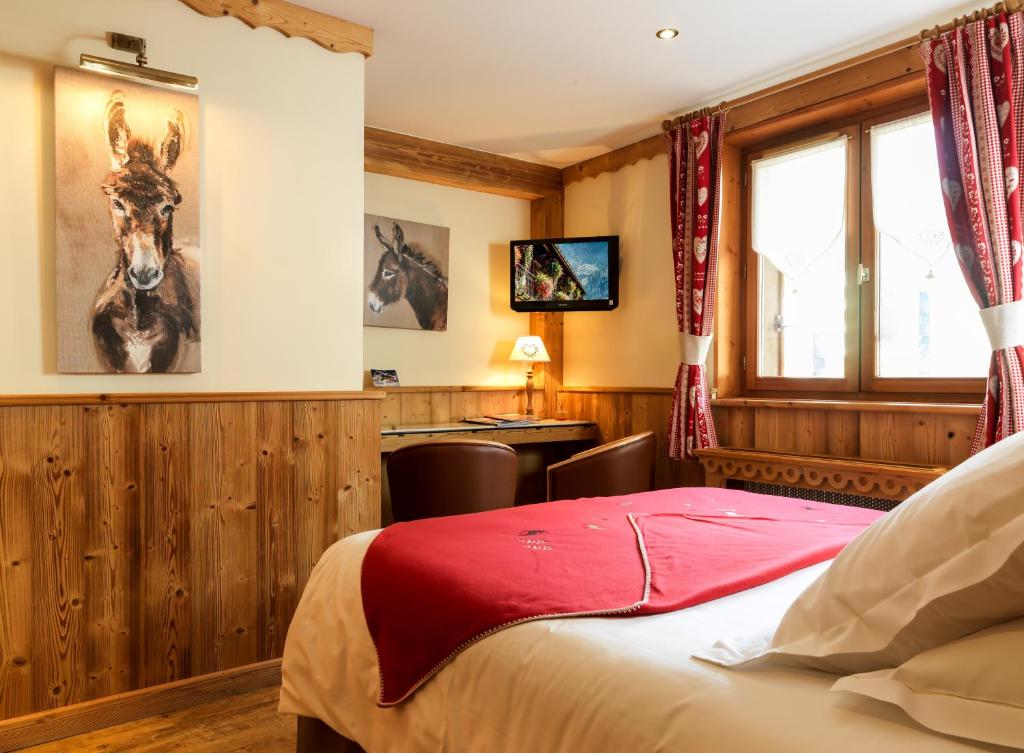 a bedroom with a bed and a desk in a room at Auberge du Manoir in Chamonix