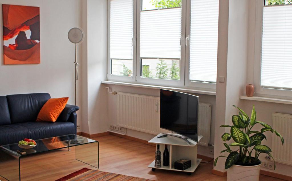 a living room with a couch and a flat screen tv at Wohnen am Roseneck in Berlin