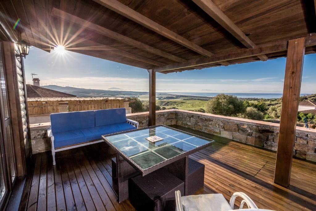 patio z niebieską kanapą i stołem na pokładzie w obiekcie Rural Tarifa Beach Las Cabañas w mieście Tarifa
