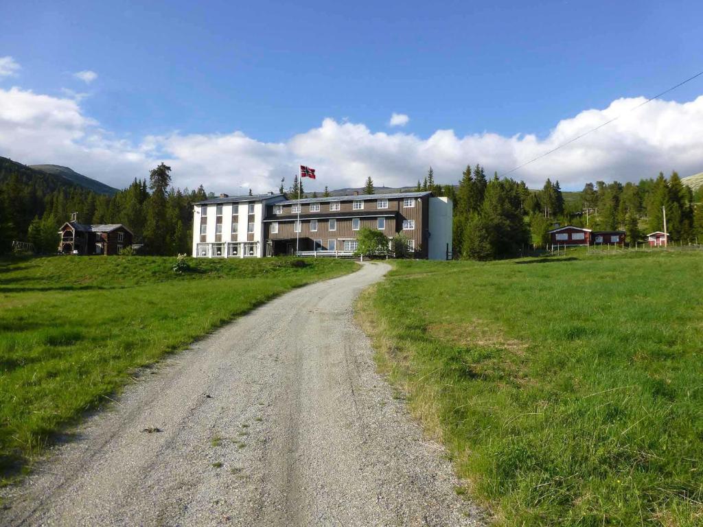 a dirt road in front of a large building at Tronsvangen Seter in Alvdal