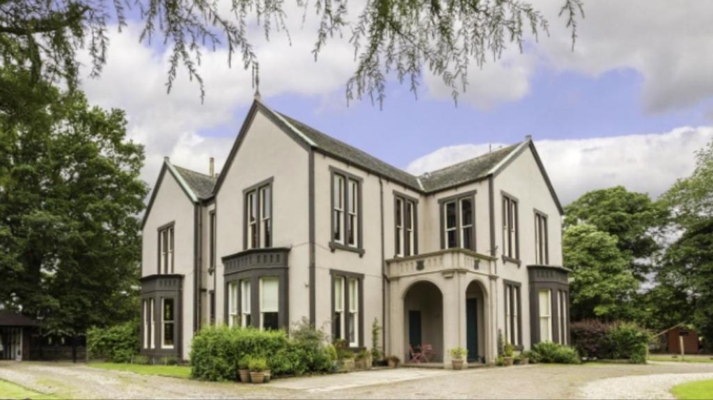 ein großes weißes Haus mit einem Turm in der Unterkunft Fernlea spacious apartment in Arbroath